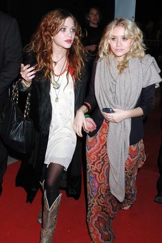 two beautiful young women walking down a red carpet