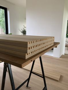 a table that has some kind of wooden structure on it's legs in front of a window