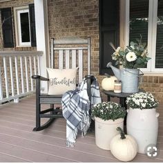 a porch decorated for thanksgiving with white pumpkins and flowers