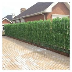 a tall bamboo fence next to a house