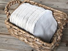 a wicker basket with white towels in it