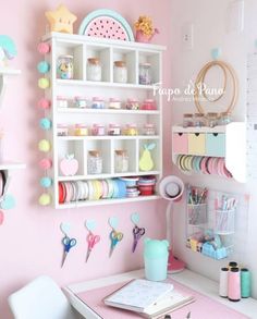 a craft room with pink walls and white shelves