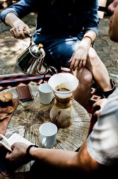 two people sitting at a table with coffee and pastries