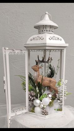 a white lantern with ornaments and deer on it