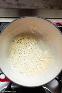 a white bowl filled with liquid on top of a stove