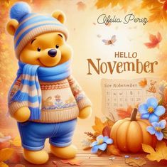 a teddy bear wearing a blue hat and scarf standing next to a calendar with autumn leaves on it