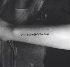 a woman with a tattoo on her arm that says, power to the law in black and white