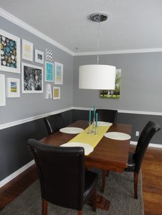 a dining room table with chairs and pictures on the wall