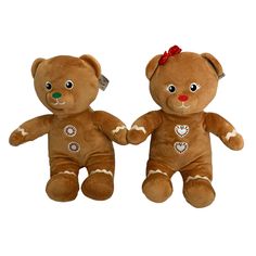 two brown teddy bears sitting next to each other with hearts on their chest and eyes