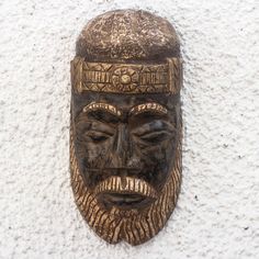 a wooden mask mounted to the side of a wall