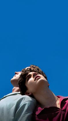 a young man is looking up into the sky with his head resting on his arm