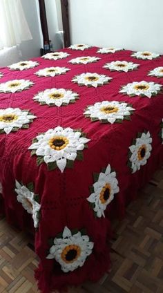 a red bedspread with white and yellow flowers on it