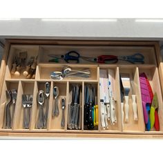 an open drawer with utensils in it