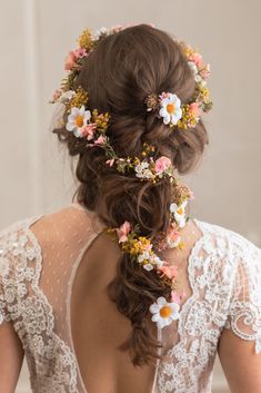 the back of a woman's head with flowers in her hair, wearing a wedding dress