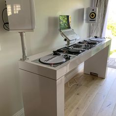 two turntables sitting on top of a white table in front of a window