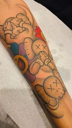 a person with a tattoo on their arm that has an image of two cartoon characters