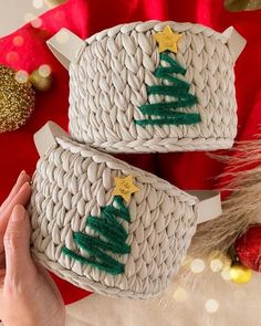 two baskets with christmas trees on them are sitting next to each other, one is made from woven material and the other has gold stars