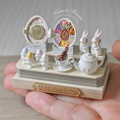 a miniature figurine is displayed in the palm of someone's hand,