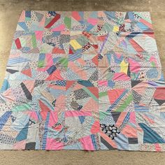 a very colorful quilt sitting on the floor