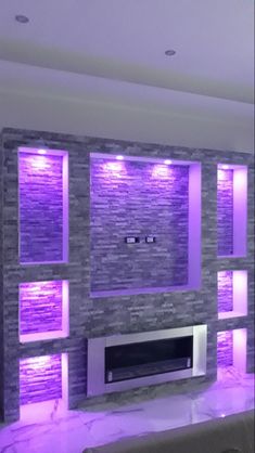 a living room filled with furniture and purple lights on the wall above it's fireplace