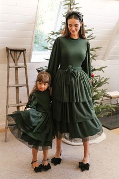 Winter season calls for warm fashion and we've created just that. The perfect mix of forest green, ribbed, knit sweater material, balloon sleeves, and layers and layers of tulle. Nothing screams comfort and fashion quite like the Cosette Dress. This lovely little number has a little bit of stretch and an optional waist tie which looks stunning tied in the front or back. Green Dress Modest, Tool Skirt, Tulle Outfit, Forest Green Dress, Black Velvet Bow, Heavy Dresses, Layered Tulle Skirt, City Woman, Bow Heels