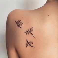 the back of a woman's shoulder with three small flowers on it