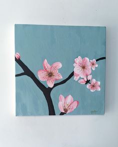 a painting of pink flowers on a teal blue background with black branches and leaves