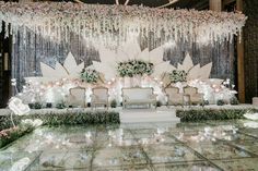 an elaborately decorated stage with flowers and chandelier for a wedding or reception