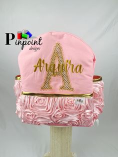 a pink hat with gold letters on it