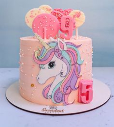 a birthday cake decorated with an unicorn's head and number 10 on top, sitting on a plate