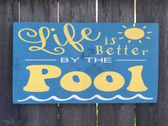 a wooden sign that says life is better by the pool