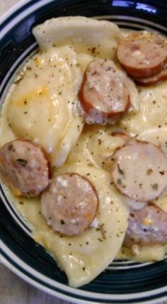 a blue and white bowl filled with pasta and sausage