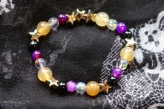 Nonbinary pride flag star beaded gemstone bracelet. The beads are the nonbinary flag colors (yellow, white, purple, black) and gold stars. ♥ Bracelet Size: - To find the size that fits you best, you can measure the circumference around your wrist; for a comfort/loose fit, add 2cm to that measurement ♥ Handcrafted With: ✔ High-quality gemstone beads ✔ Durable stretchy cord Thank you for visiting! If you have any questions, feel free to contact me!  Instagram: @FrogsMakingToast Purple Star-shaped Bracelets For Gifts, Purple Star-shaped Bracelet For Gift, Nonbinary Jewelry, Nonbinary Bracelet, Subtle Nonbinary, Lgbtq Bracelet, Ombre Fringe Earrings, Lgbtq Gifts, Lgbtq Jewelry