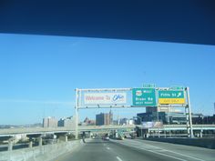 an interstate highway with street signs and buildings in the background