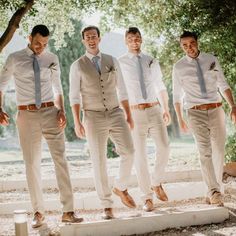 a group of men standing next to each other on top of a cement slab in front of trees