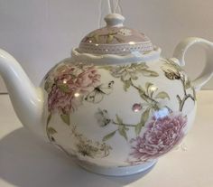 a tea pot with flowers painted on it