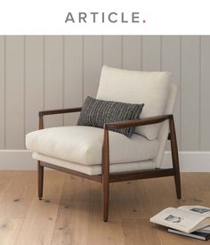 a chair sitting on top of a hard wood floor next to a book and magazine