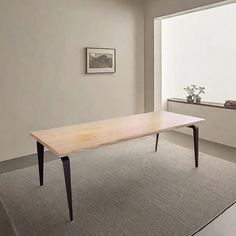 a white table sitting on top of a rug next to a window