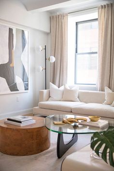 a living room filled with furniture and a large painting hanging on the wall above it