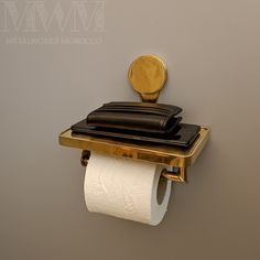 a toilet paper holder with two rolls of toilet paper on it and a gold plate mounted to the wall