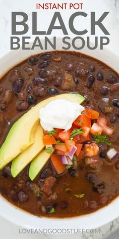 black bean soup with avocado and sour cream in a white bowl