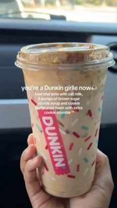 someone holding up a dunkin'donuts drink in their hand