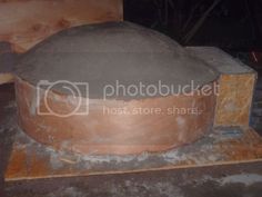 a large cement pot sitting on top of a wooden block