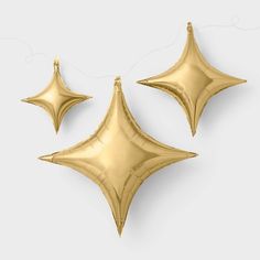 three gold foil balloons in the shape of stars