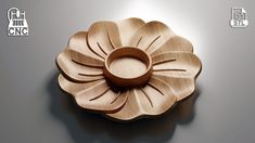 a wooden flower shaped object on a gray surface