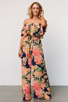 Capistrano Ruffle Jumpsuit | Navy Floral Summer Off-shoulder Ruffled Jumpsuits And Rompers, Chic Off-shoulder Beach Jumpsuits And Rompers, Chic Off-shoulder Jumpsuits And Rompers For Beach, Summer Beach Jumpsuits And Rompers With Ruffles, Summer Off-shoulder Jumpsuits And Rompers, Spring Tropical Printed Jumpsuits And Rompers, Summer Off-shoulder Floral Jumpsuits And Rompers, Casual Off-shoulder Jumpsuits And Rompers For Vacation, Chic Floral Print Beach Jumpsuit