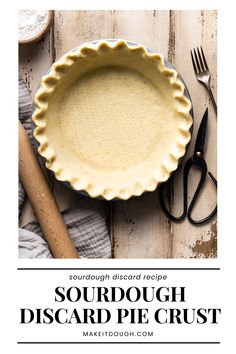 an image of a pie crust in a pie pan on a wooden table with utensils