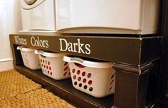 three white laundry baskets sitting on top of a shelf next to a washer and dryer