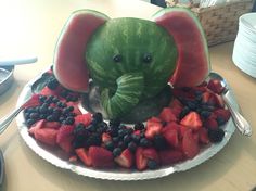 an elephant made out of watermelon and berries on a plate