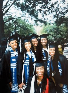 a group of people standing next to each other wearing graduation caps and gowns